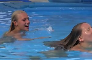 Two beautiful girls swimming together with licking by dramatize expunge pool